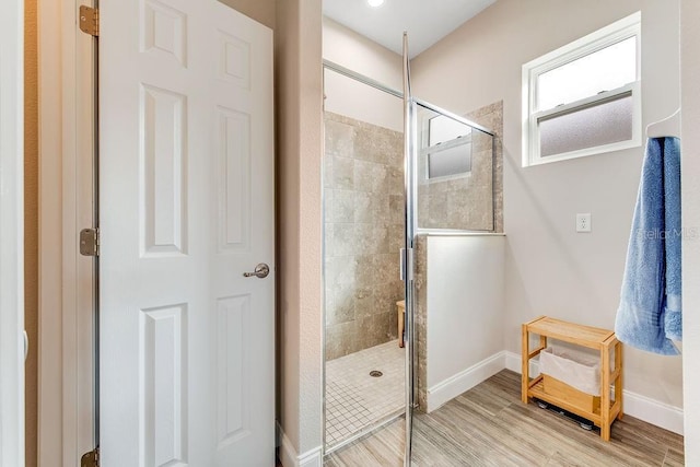 bathroom with wood-type flooring and an enclosed shower