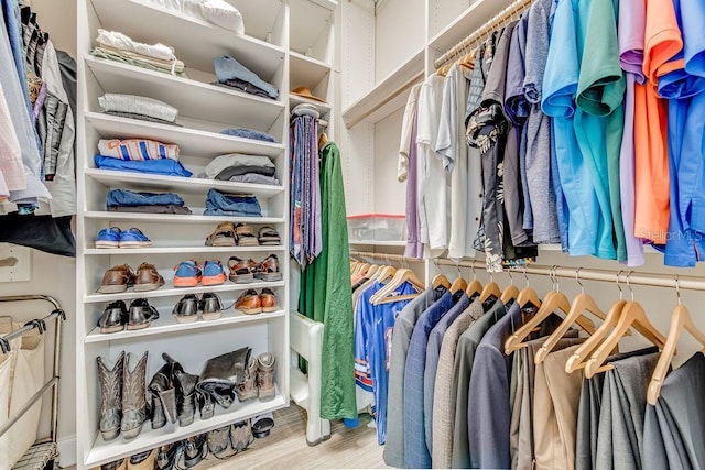 walk in closet with light hardwood / wood-style flooring