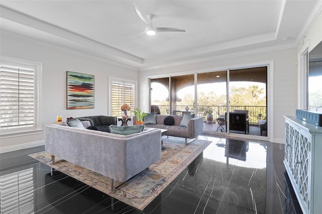 living room with ceiling fan, a raised ceiling, and ornamental molding