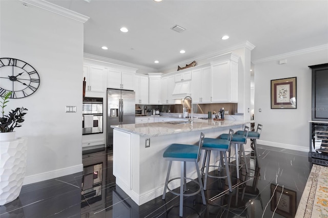 kitchen with white cabinets, kitchen peninsula, crown molding, and sink