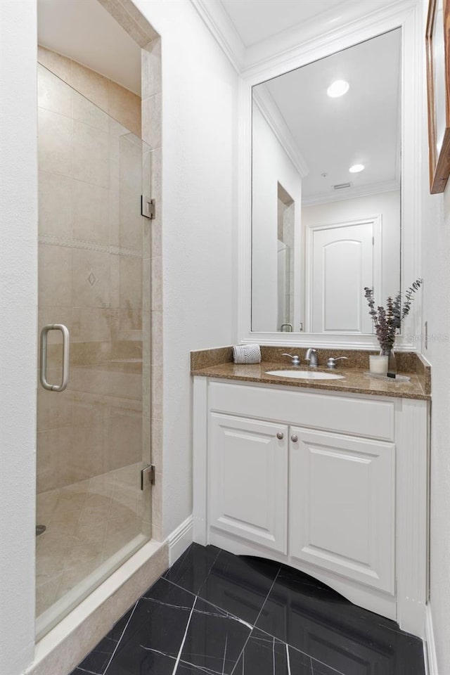 bathroom with vanity, a shower with shower door, and crown molding