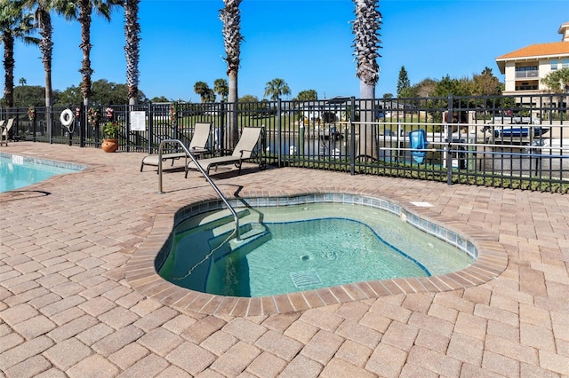 view of swimming pool featuring a patio area and a hot tub