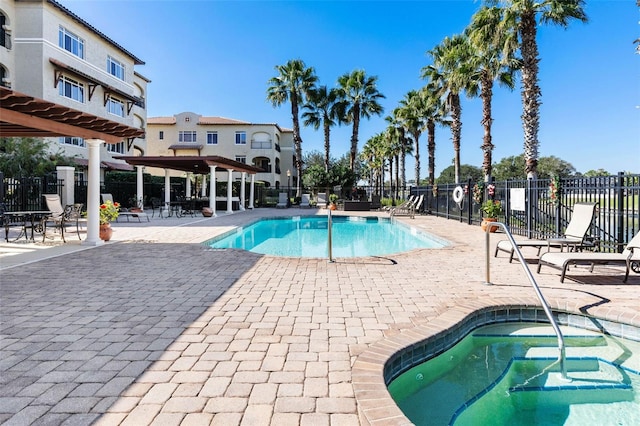 view of swimming pool with a patio and a hot tub