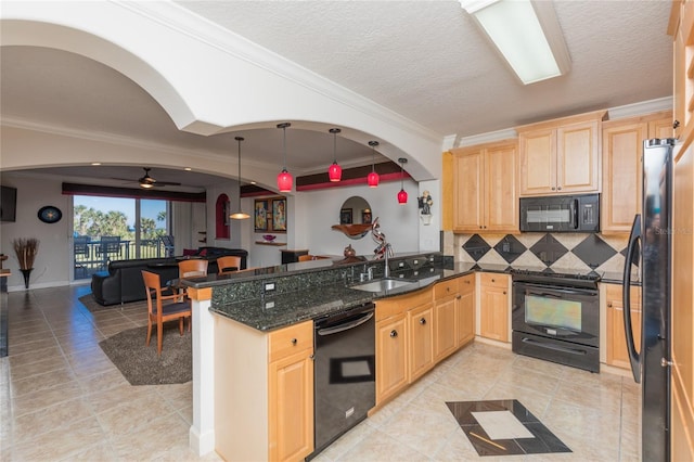 kitchen featuring black appliances, dark stone countertops, ornamental molding, decorative light fixtures, and kitchen peninsula