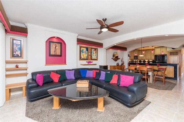 living room featuring crown molding, ceiling fan, and a textured ceiling