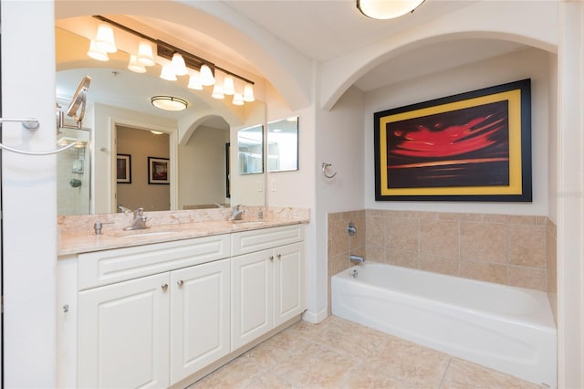 bathroom with tile patterned floors, vanity, and a bath