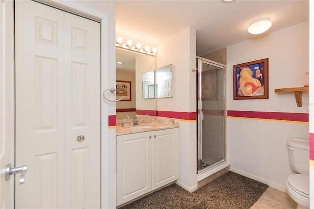 bathroom featuring tile patterned flooring, vanity, toilet, and walk in shower