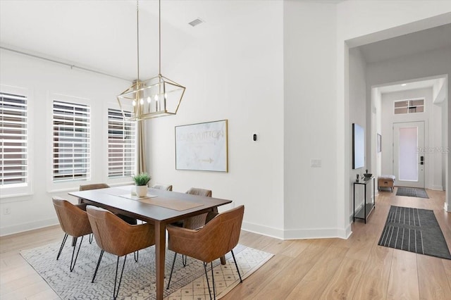 dining area featuring light hardwood / wood-style floors and an inviting chandelier