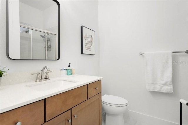 bathroom featuring tile patterned floors, vanity, toilet, and a shower with shower door