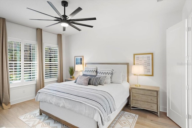 bedroom with multiple windows, ceiling fan, and light wood-type flooring