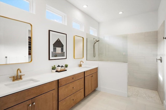 bathroom featuring a tile shower, vanity, and tile patterned floors