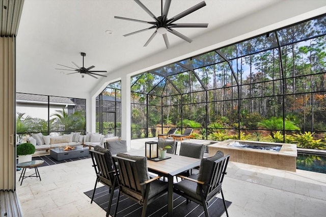 view of patio / terrace with glass enclosure, ceiling fan, an in ground hot tub, and an outdoor living space with a fire pit