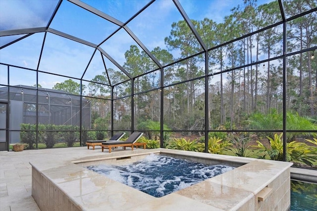 view of swimming pool featuring glass enclosure, a jacuzzi, and a patio