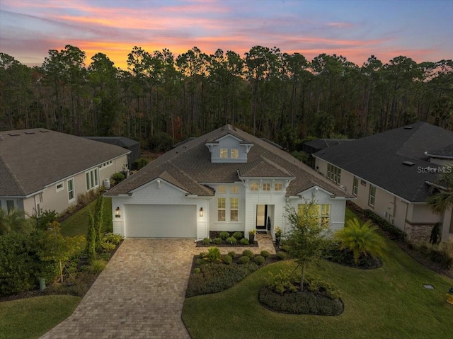 view of front of home with a yard and a garage