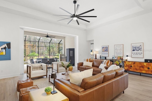 living room with light hardwood / wood-style flooring and a tray ceiling