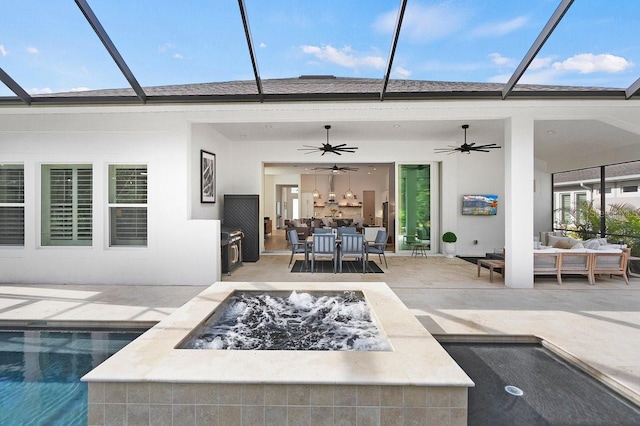 view of patio with ceiling fan and an outdoor living space with a fire pit