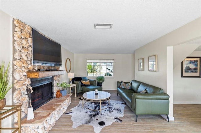 living room featuring a fireplace, hardwood / wood-style floors, and a textured ceiling