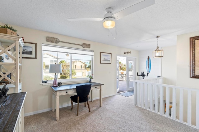 carpeted office space with a textured ceiling and ceiling fan