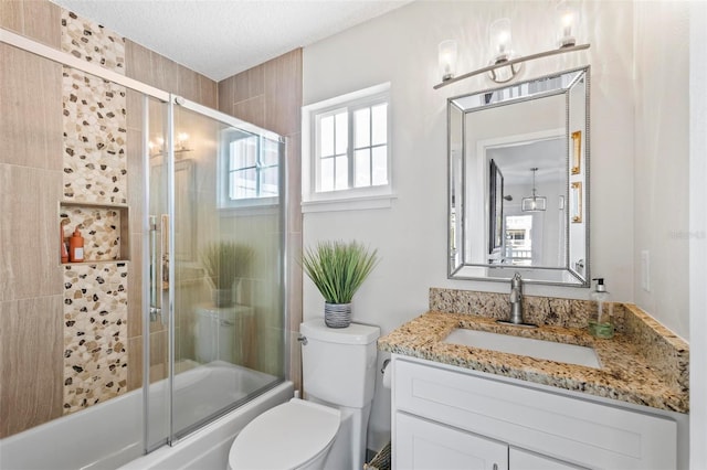 full bathroom featuring a textured ceiling, vanity, toilet, and enclosed tub / shower combo