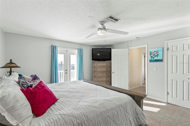 carpeted bedroom with access to exterior, french doors, a textured ceiling, and ceiling fan