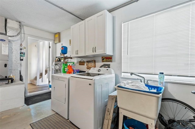 washroom featuring washer and clothes dryer, cabinets, a textured ceiling, and sink