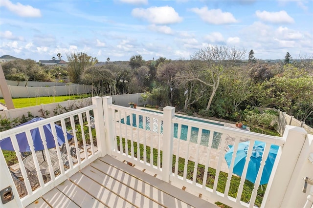 deck with a fenced backyard and a fenced in pool