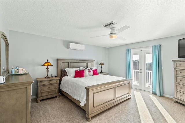 bedroom featuring visible vents, ceiling fan, a wall unit AC, light carpet, and access to outside