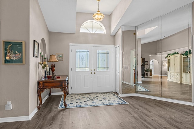 entrance foyer featuring a towering ceiling and dark wood-type flooring