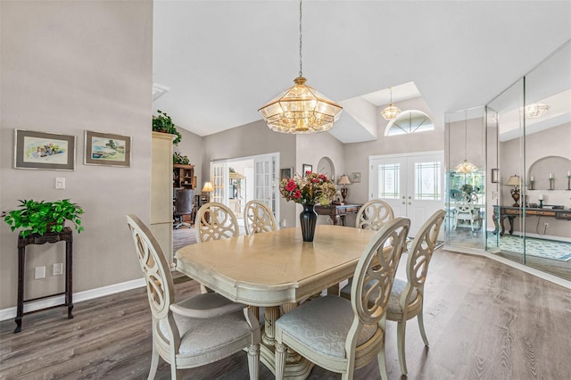 dining space featuring a notable chandelier, french doors, vaulted ceiling, and dark hardwood / wood-style floors