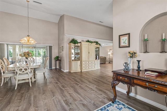 entryway with hardwood / wood-style floors and high vaulted ceiling