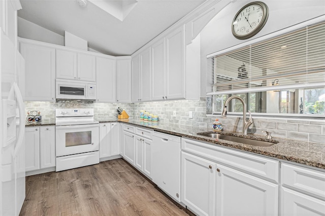 kitchen with white appliances, white cabinets, lofted ceiling, and sink