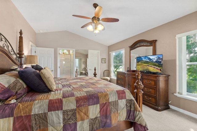 bedroom featuring vaulted ceiling, ensuite bath, light colored carpet, and ceiling fan