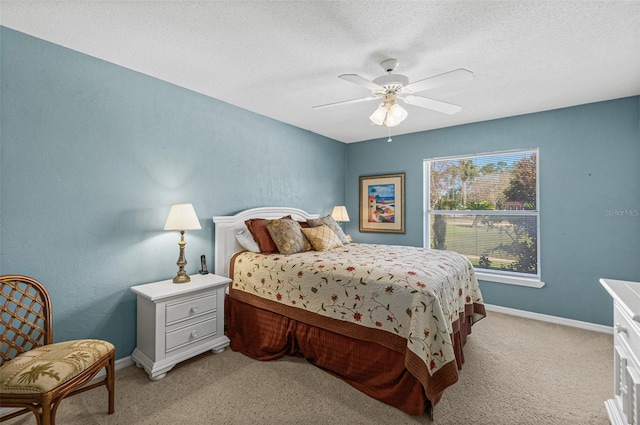 carpeted bedroom featuring a textured ceiling and ceiling fan