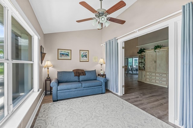 living room featuring ceiling fan, vaulted ceiling, and wood-type flooring