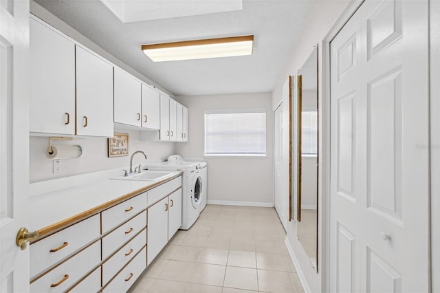 washroom featuring sink, washing machine and dryer, light tile patterned floors, and cabinets