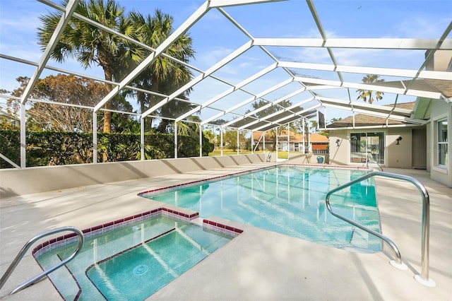 view of pool featuring a patio area, glass enclosure, and an in ground hot tub