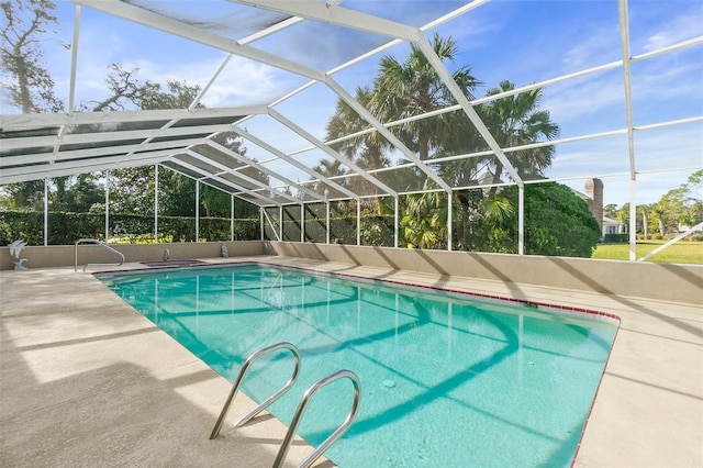 view of pool with a patio area and glass enclosure