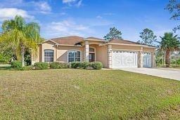 single story home with a garage and a front lawn