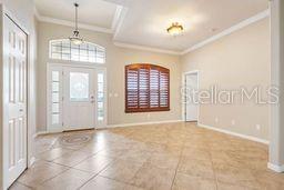 entryway with tile patterned flooring and crown molding