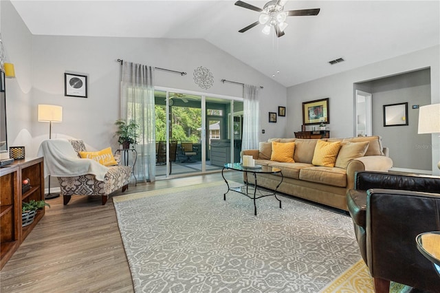 living room with light hardwood / wood-style floors, vaulted ceiling, and ceiling fan