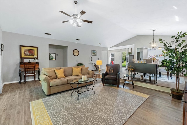 living room featuring hardwood / wood-style flooring, ceiling fan with notable chandelier, lofted ceiling, and french doors