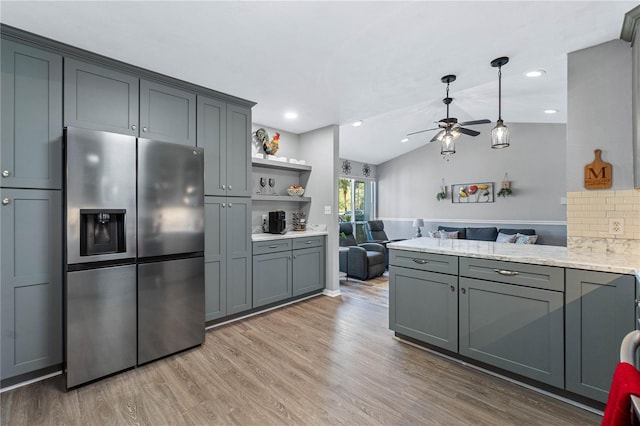 kitchen with ceiling fan, tasteful backsplash, stainless steel fridge, gray cabinets, and hardwood / wood-style flooring