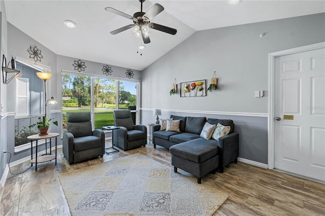 living room with hardwood / wood-style flooring, ceiling fan, and lofted ceiling