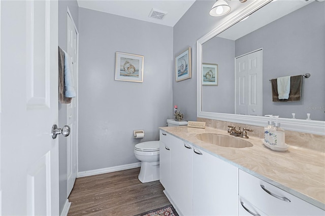 bathroom featuring vanity, wood-type flooring, and toilet