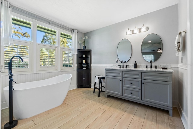 bathroom featuring wood-type flooring, vanity, and a bathtub