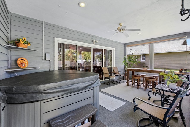 sunroom / solarium with a jacuzzi and ceiling fan