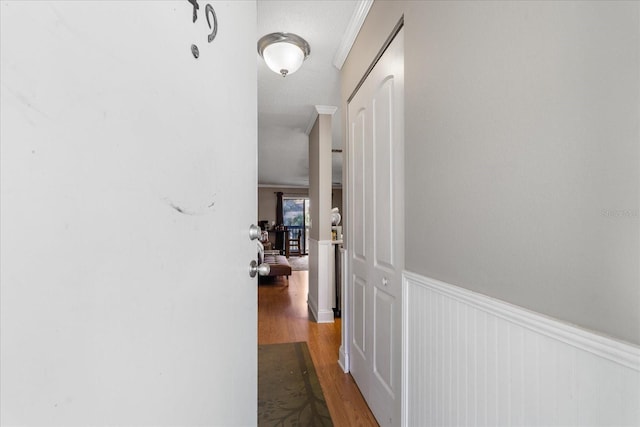 hall with a textured ceiling, hardwood / wood-style flooring, and crown molding