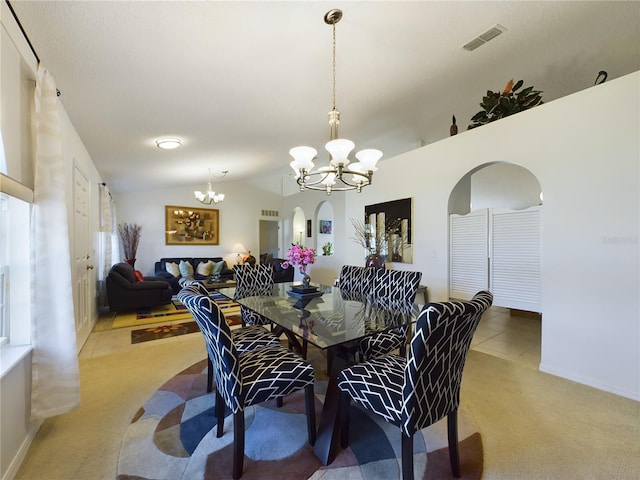 tiled dining room featuring arched walkways, vaulted ceiling, carpet flooring, and a notable chandelier