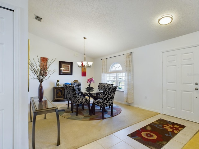 dining area with lofted ceiling, a textured ceiling, visible vents, and tile patterned floors