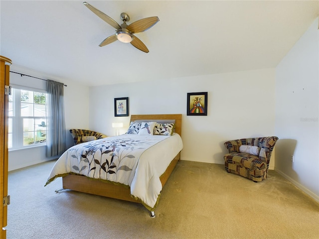 bedroom with a ceiling fan, light colored carpet, and baseboards